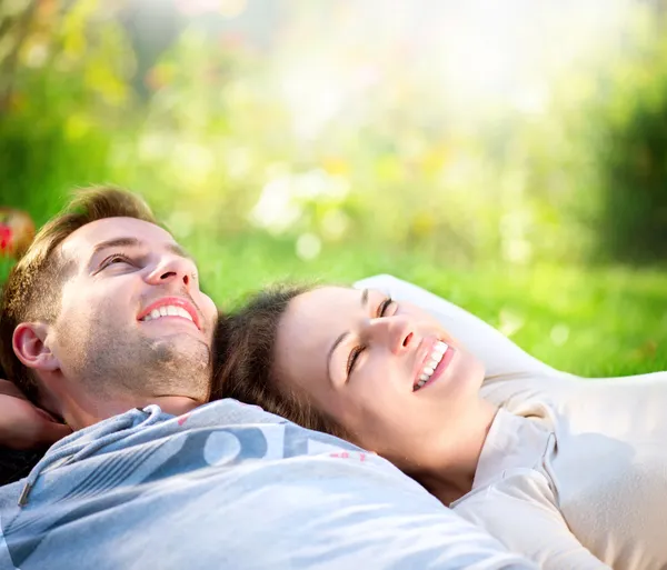 Young Couple Lying on Grass Outdoor Royalty Free Stock Images