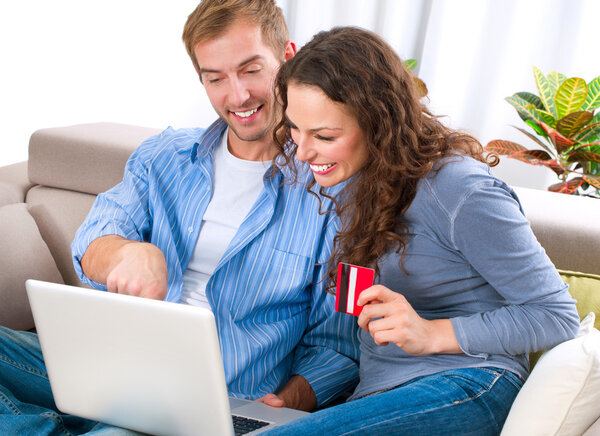 Pareja joven con ordenador portátil y tarjeta de crédito compra en línea — Foto de Stock