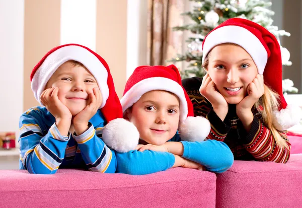 Noel çocuk. Mutlu küçük çocuklara Noel Baba'nın şapkası — Stok fotoğraf