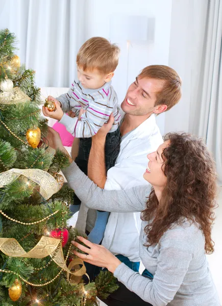 Young Family decorating a Christmas Tree Stock Image
