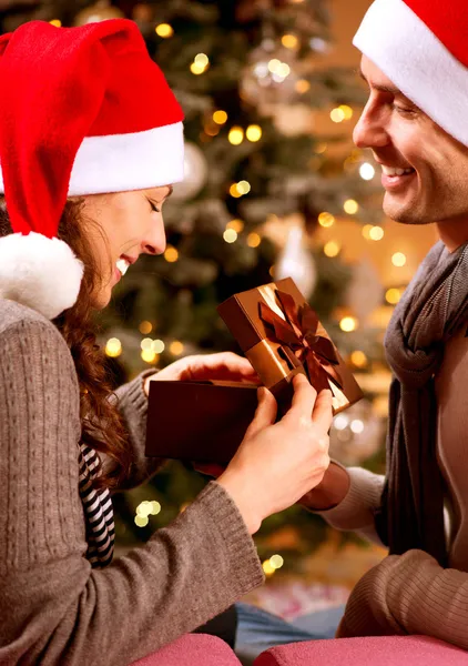 Escena de Navidad. Pareja feliz con regalo de Navidad en casa —  Fotos de Stock