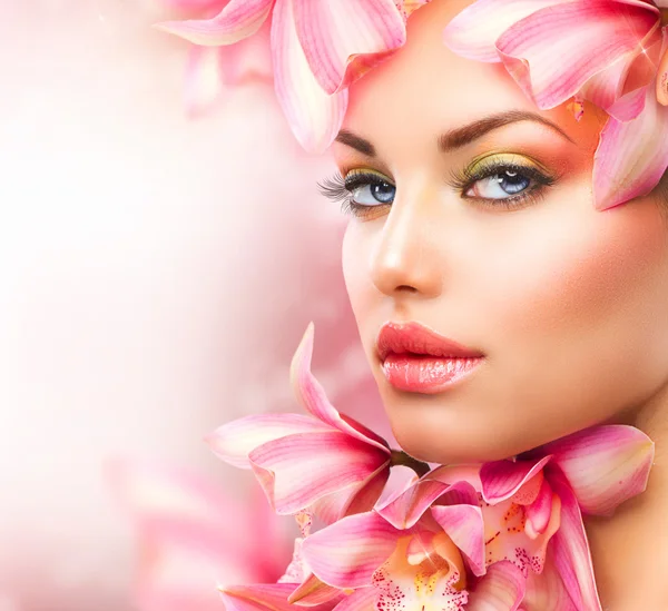 Hermosa chica con flores de orquídea. Belleza mujer cara — Foto de Stock