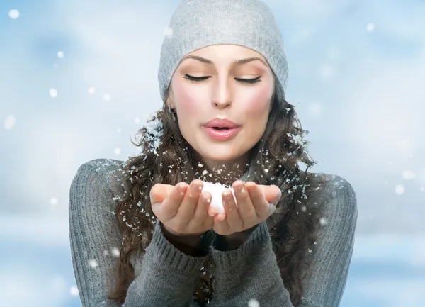 Weihnachtsmädchen. Winterfrau bläst Schnee — Stockfoto