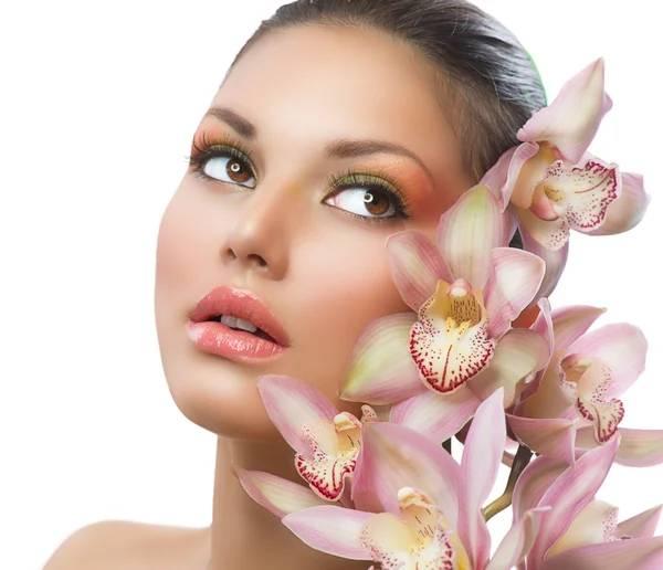 Hermosa chica con flores de orquídea. Belleza mujer cara — Foto de Stock