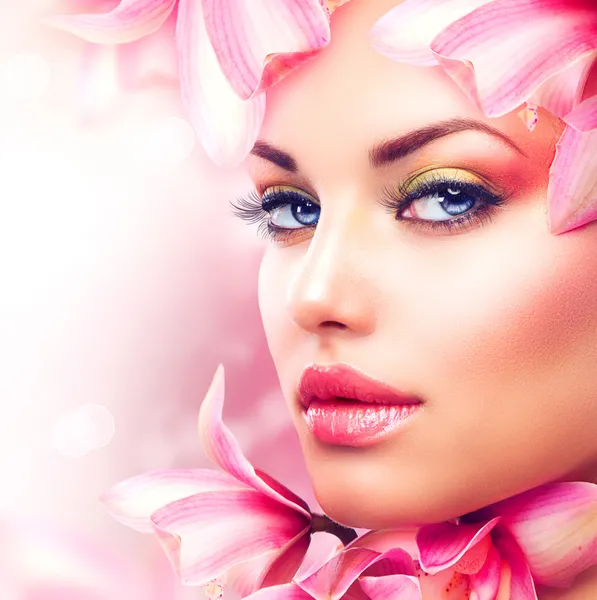 Piękna dziewczyna z kwiaty orchidei. piękna twarz kobiety — Zdjęcie stockowe