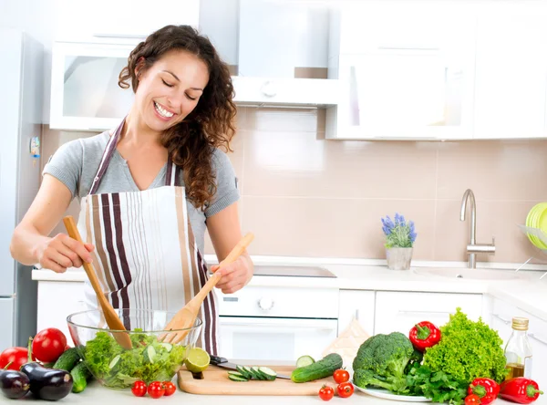 烹饪的年轻女子。健康食品-蔬菜沙拉 图库照片