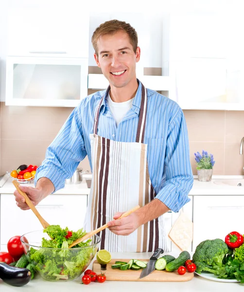 若い男の料理します。健康食品 - 野菜のサラダ — ストック写真