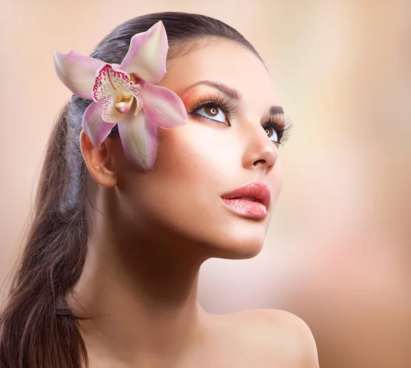 Schoonheid portret. mooi stijlvol meisje met orchideebloem — Stockfoto