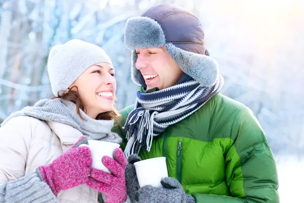 Szczęśliwa para z zimnymi napojami na świeżym powietrzu. Ferie zimowe — Zdjęcie stockowe
