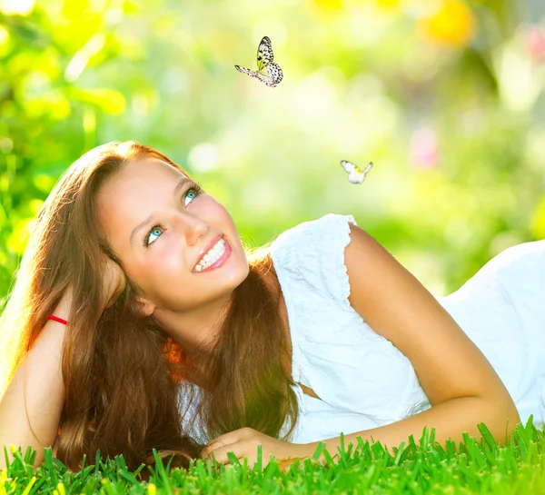 Frühlingsschönheit. schönes Mädchen liegt auf grünem Gras im Freien — Stockfoto