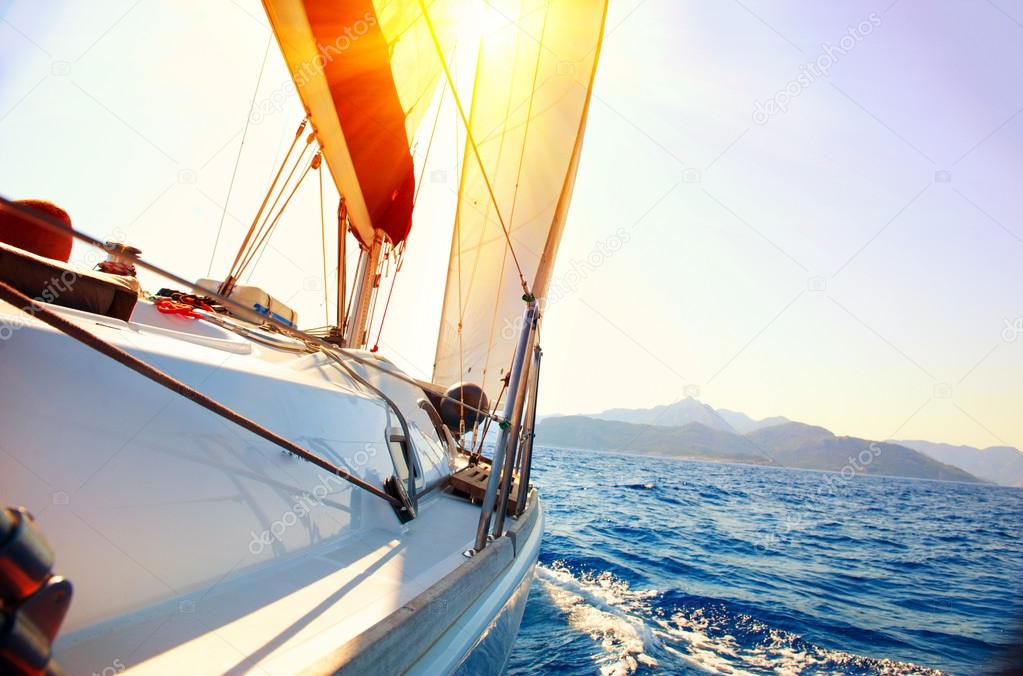 Yacht Sailing against sunset. Sailboat. Yachting. Sailing