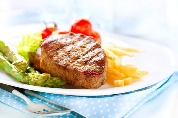 Carne de ternera a la parrilla con patatas fritas, espárragos, tomates — Foto de Stock