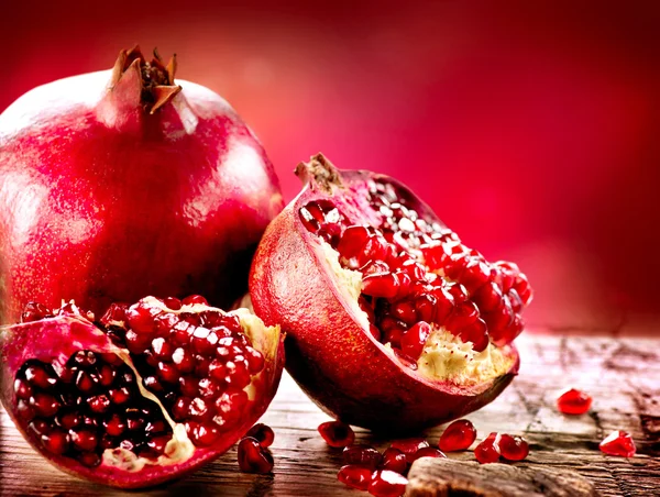 Pomegranates over Red Background. Organic Bio fruits — Stock Photo, Image