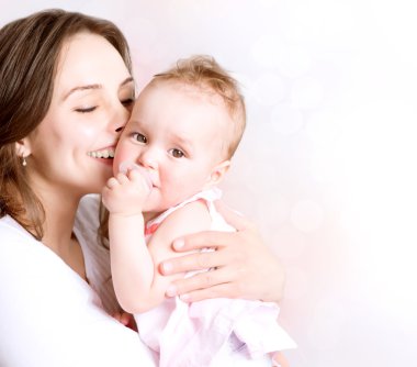 Anne ve bebek öpüşüyor ve sarılıyorlar. Mutlu Aile