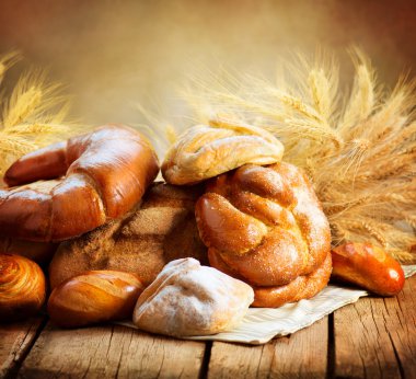 ahşap bir masa üzerinde fırın ekmek. çeşitli ekmek ve demeti