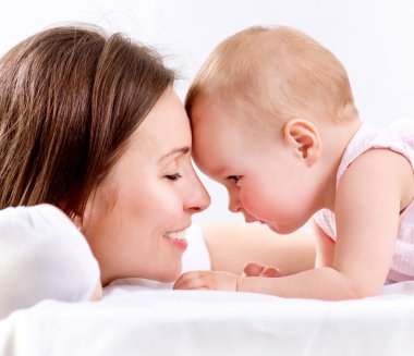 Anne ve bebek öpüşüyor ve sarılıyorlar. Mutlu Aile