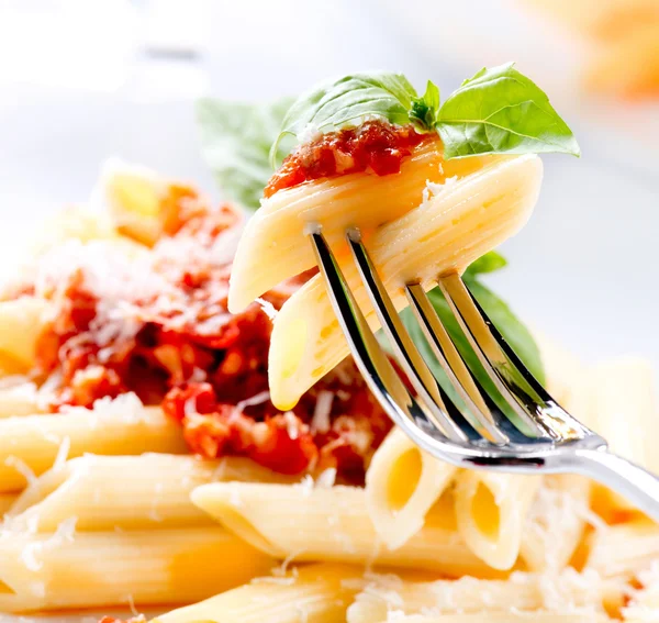 Penne Pasta con salsa boloñesa, queso parmesano y albahaca —  Fotos de Stock