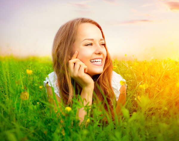 Красавица в Медоу, лежащая на Зеленом Грасе с дикими фловерами
