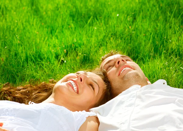 Happy Smiling Couple Relaxing on Green Grass. Park Stock Photo