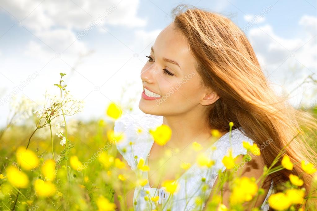 Beauty Girl in the Meadow lying on Green Grass