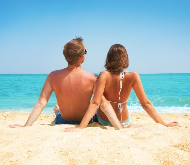 genç bir çift birlikte sahilde oturuyor. tatil kavramı