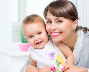 Anne ve bebek öpüşüyor ve sarılıyorlar. Mutlu Aile