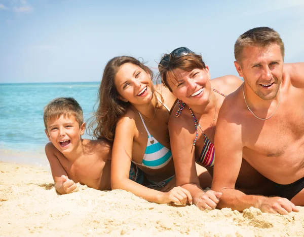 Familia feliz divirtiéndose en la playa. Concepto de vacaciones — Foto de Stock