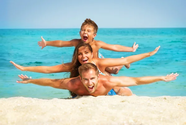 Glad ung familj med litet barn ha roligt på stranden — Stockfoto