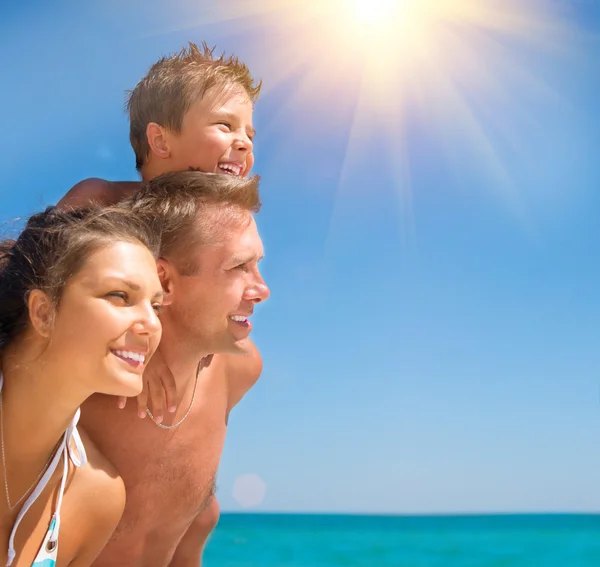 Familia joven y feliz con niño divirtiéndose en la playa Imagen De Stock