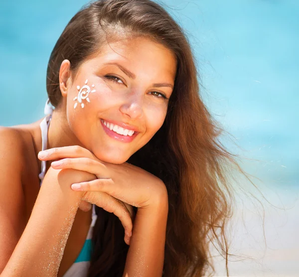 Belle fille heureuse appliquant Sun Tan Cream sur son visage — Photo