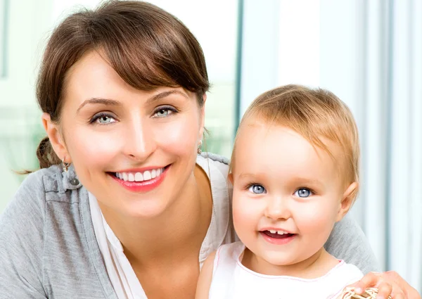 Feliz Sorrindo Mãe e Bebê beijando e abraçando em casa — Fotografia de Stock