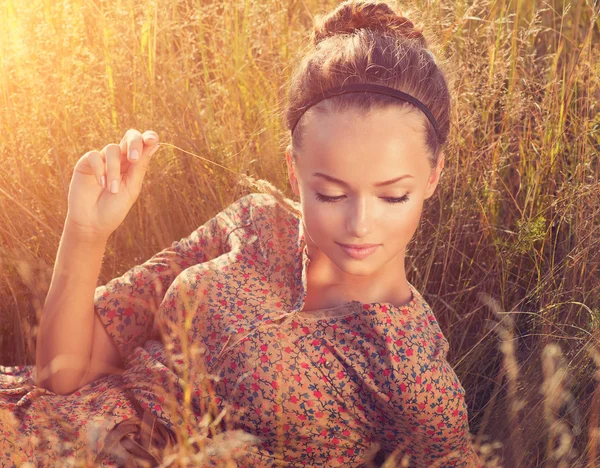 Romantische meisje schoonheid liggend op het veld in zonlicht — Stockfoto