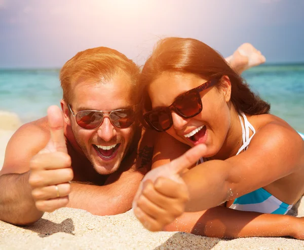 Felice coppia in occhiali da sole divertirsi sulla spiaggia — Foto Stock