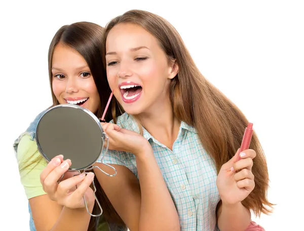 Meninas muito adolescentes aplicando maquiagem e olhando no espelho — Fotografia de Stock