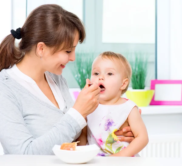 Matka krmí svou holčičku lžící — Stock fotografie