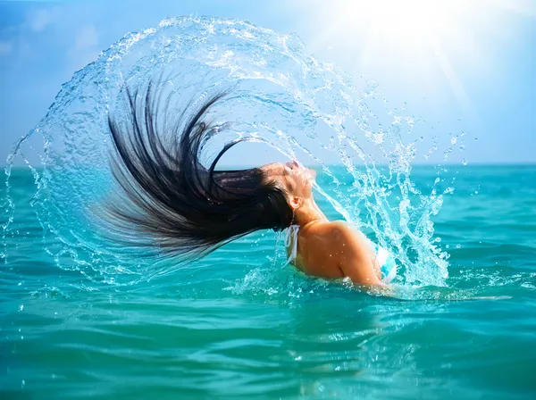 Schoonheid model meisje opspattend water met haar haren in de — Stockfoto