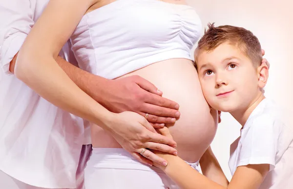 Šťastné rodiny čeká dítě. dítě naslouchání těhotné bříško — Stock fotografie