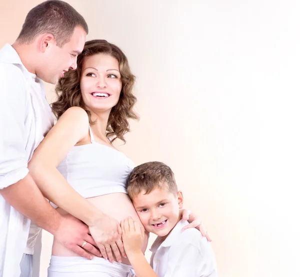 幸せな家族の期待して赤ちゃん。子供リスニング妊娠中の腹 — ストック写真