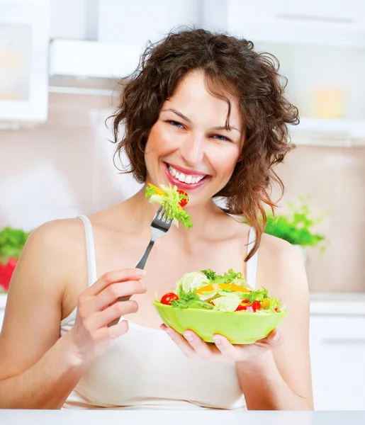 Hermosa mujer joven comiendo ensalada de verduras. Concepto de dieta — Foto de Stock