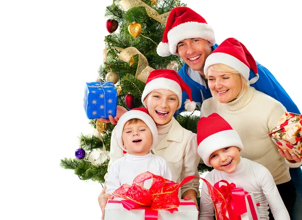 Familia navideña con regalos cerca de un árbol de Navidad Fotos De Stock Sin Royalties Gratis