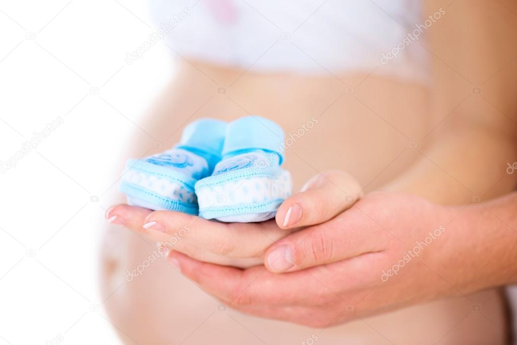 Pregnant Woman and her Husband holding Baby Shoes