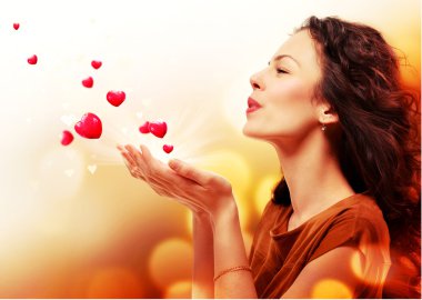Woman Blowing Hearts from her Hands. St. Valentines Day Concept
