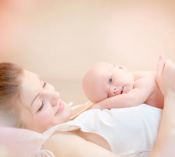 Gelukkig moeder en haar pasgeboren baby zoenen en knuffelen — Stockfoto