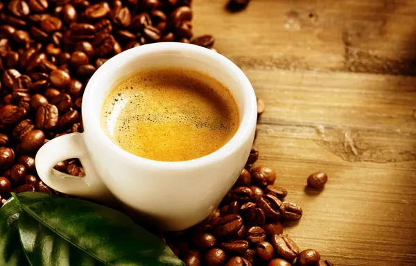 Caffe 'espresso. Tazza di caffè con fagioli e foglia verde — Foto Stock