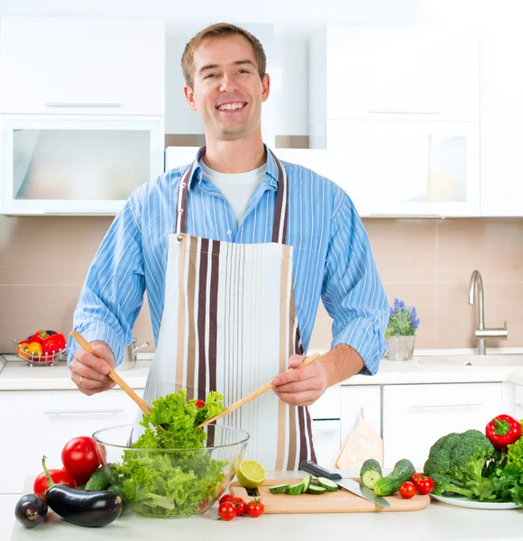 Mladý muž, vaření. zdravé potraviny - zeleninový salát — Stock fotografie