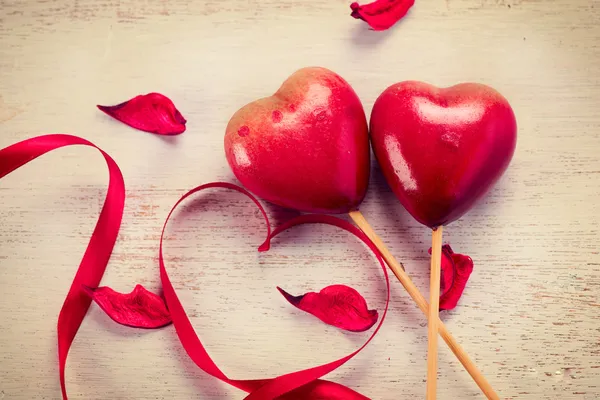 Fita de cetim vermelho elegante e par de corações vermelhos — Fotografia de Stock