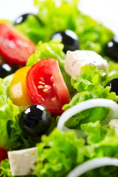 Griekse salade close-up met fetakaas, tomaten en olijven — Stockfoto