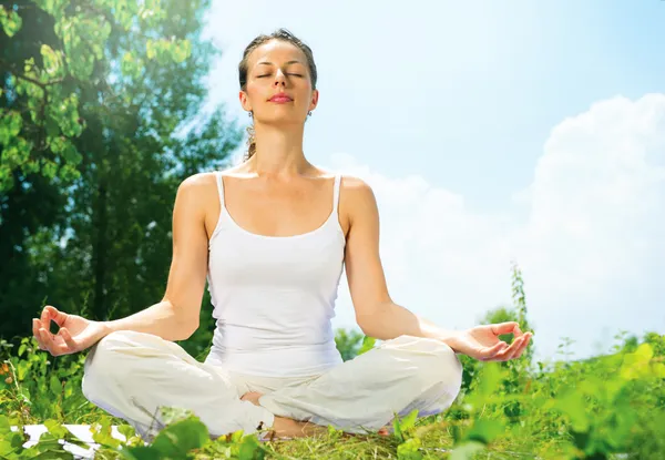 Mujer joven haciendo ejercicios de yoga al aire libre — Foto de Stock