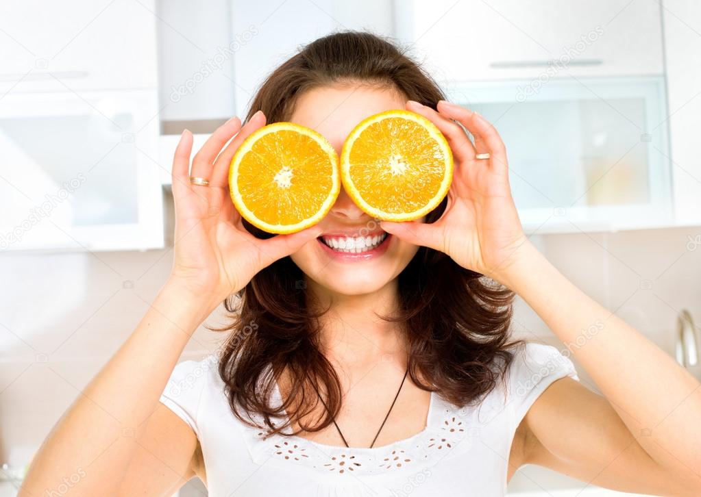 Funny Woman with Orange over Eyes in the Kitchen