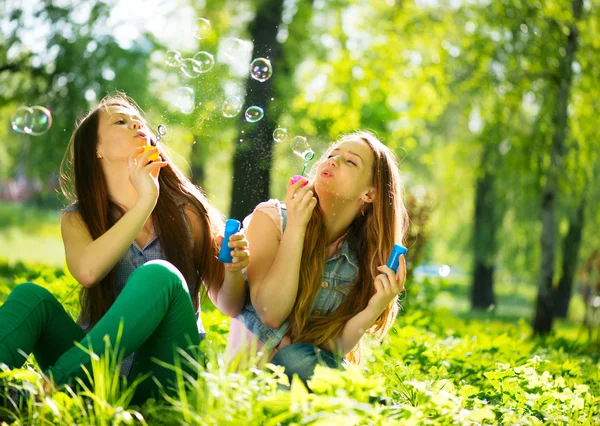 Teenage girls blowing soap bubbles — Stock Photo, Image